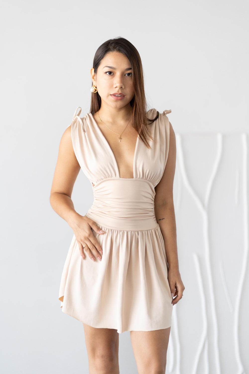 Una mujer usando un vestido color beige.